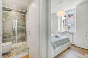 Familie appartement, meerdere slaapkamers, aan het meer (Il Porticciolo Lake Front) | Badkamer | Een douche, een haardroger, handdoeken, zeep