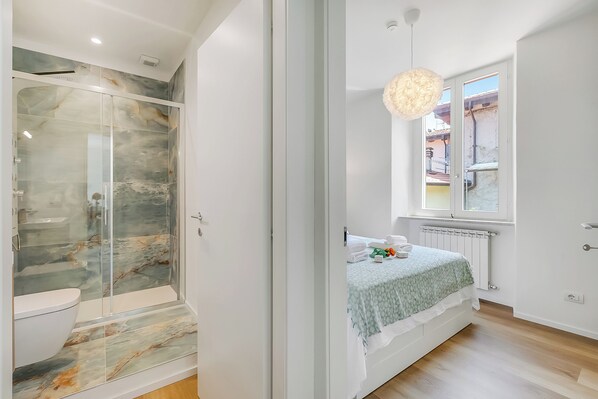 Familie appartement, meerdere slaapkamers, aan het meer (Il Porticciolo Lake Front) | Badkamer | Een douche, een haardroger, handdoeken, zeep