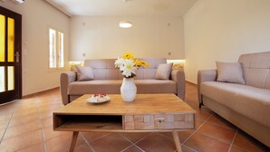 A modern living room with two sofas, a wooden coffee table, and a vase with flowers.