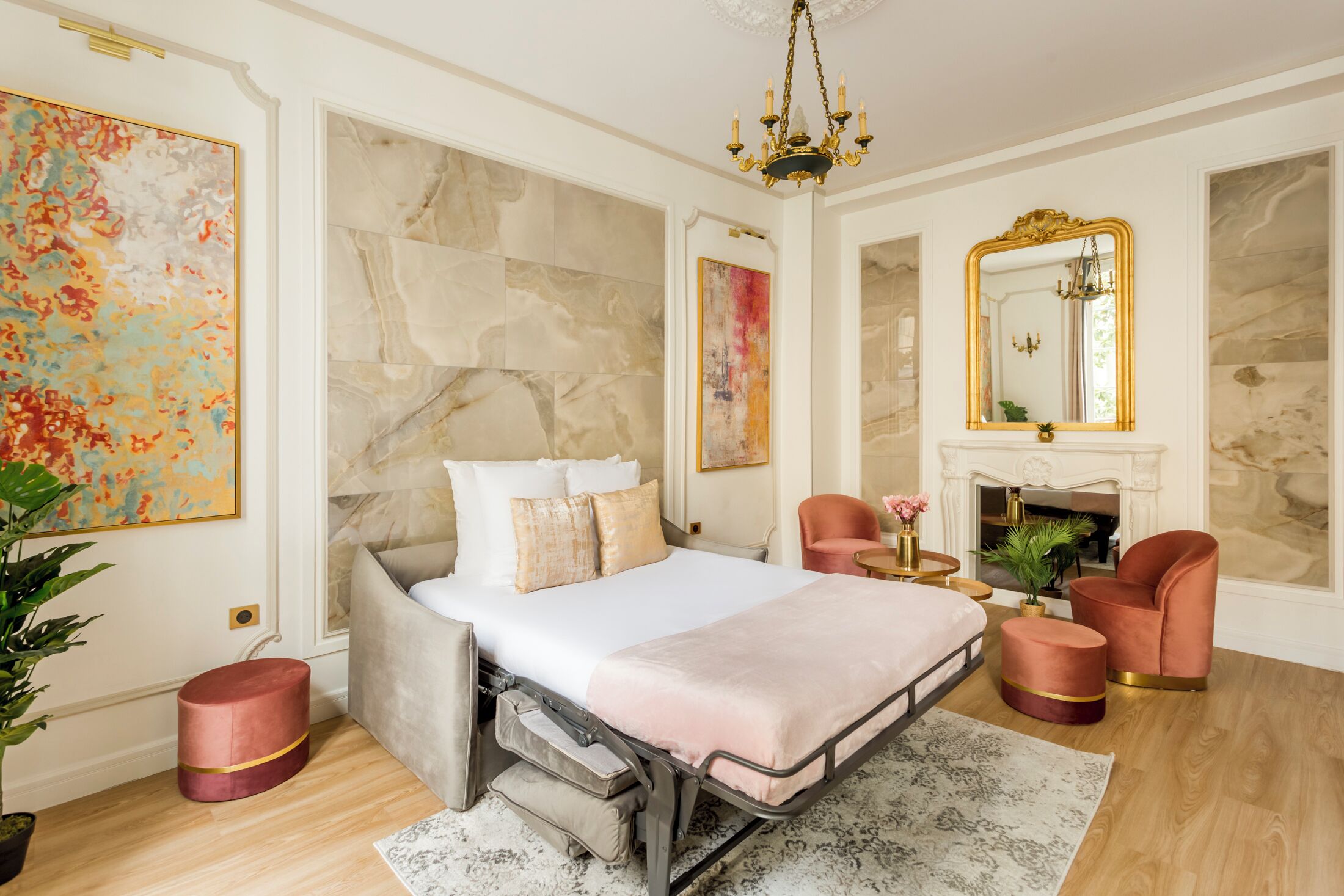 Een ruime slaapkamer met een groot bed, een open haard en een spiegel.
