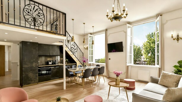 Un vaste espace de vie comprenant une cuisine moderne, un coin repas et un salon confortable.