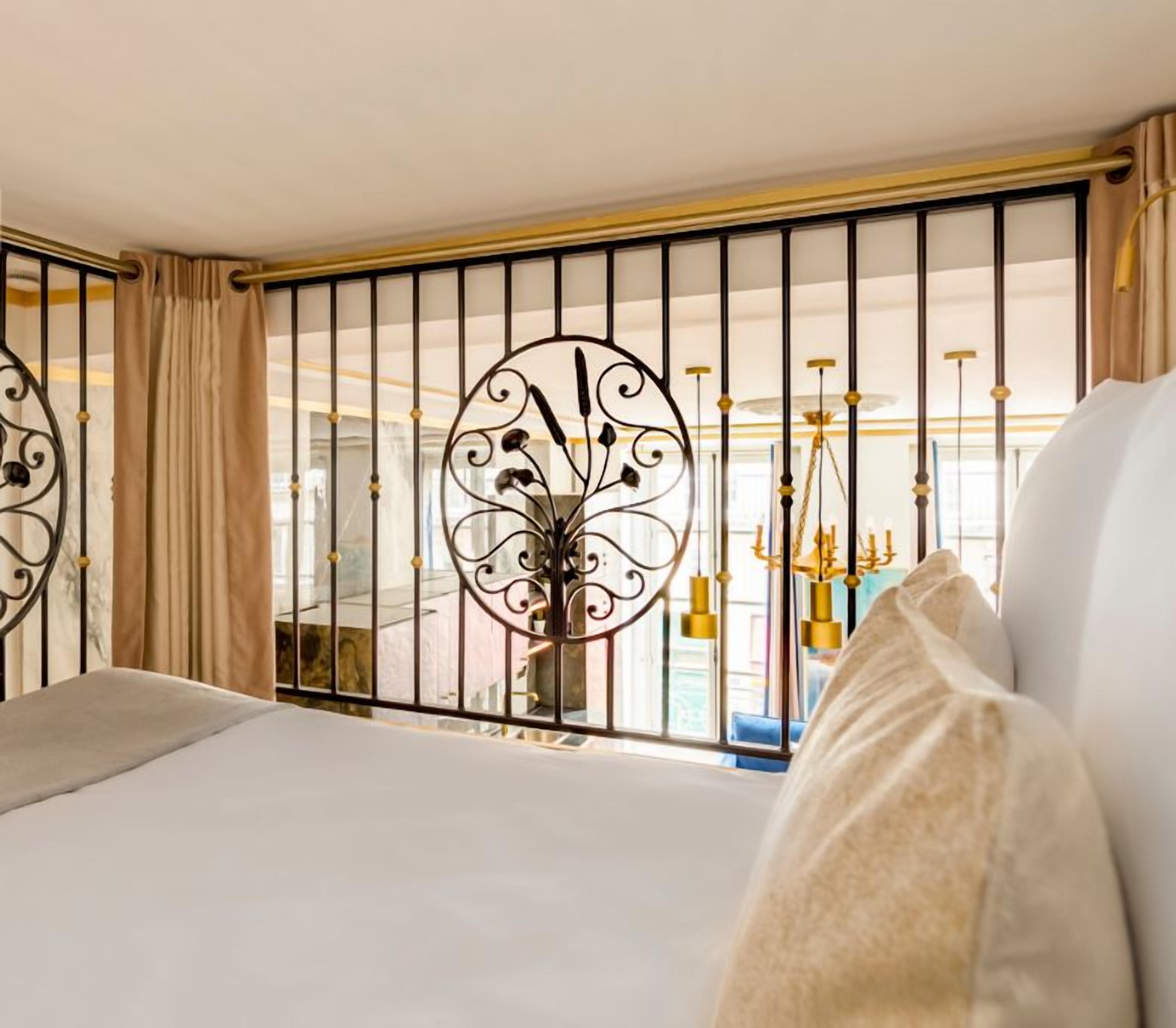 A bedroom with a bed, curtains, and a decorative metal partition.