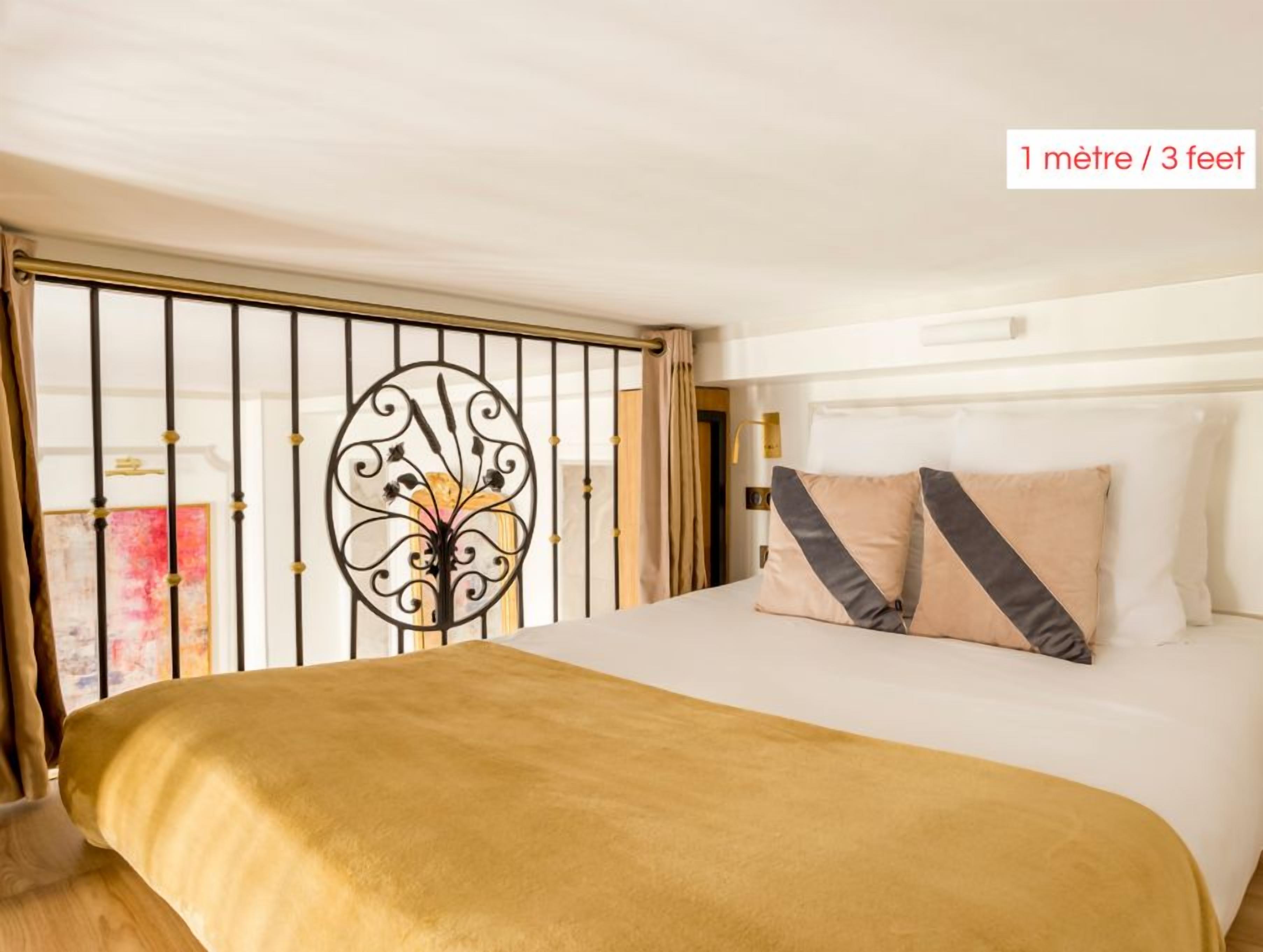 A hotel room with a bed, a decorative metal gate, and a height indicator.