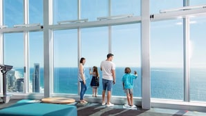 A spacious room with large windows offering a view of the ocean and city skyline. - Chic 1BR Getaway Steps from Beach&Surfers Paradise (Surfers Paradise)