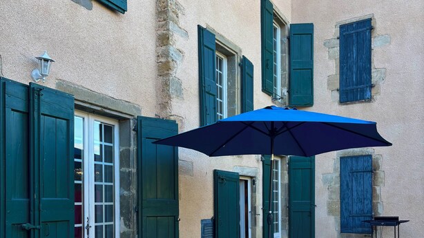 A hot tub with wicker seating and an umbrella, surrounded by stone walls and green shutters. - The Babouz Cottage, 4*,  entire house in the heart of Mirepoix and Cathars area (Mirepoix)