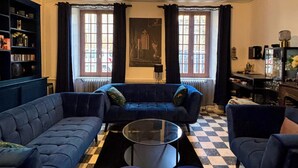 A living room with a blue sofa set, a glass coffee table, and a checkered floor. - The Babouz Cottage, 4*,  entire house in the heart of Mirepoix and Cathars area (Mirepoix)