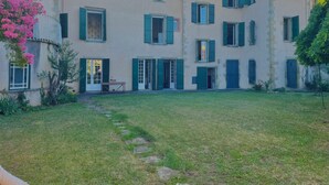 A two-story building with multiple windows and doors, a stone pathway leading to the entrance, and a grassy courtyard. - The Babouz Cottage, 4*,  entire house in the heart of Mirepoix and Cathars area (Mirepoix)