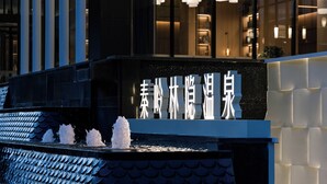 A building facade with a water feature and illuminated signage.