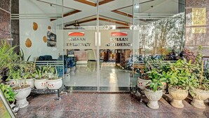 A hotel entrance with glass doors, potted plants, and a sign reading 'VHAAN RESIDENCY'. - Deluxe Hotel Vihaan Residency (Dera Bassi)