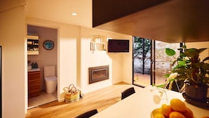 Eine moderne Küche mit Essbereich, Kamin und Blick ins Freie.