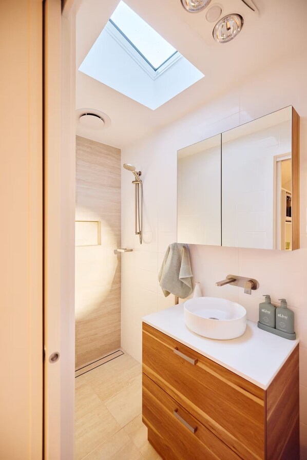 A modern bathroom with a skylight, a round sink, wooden cabinetry, and a large mirror. - Brownhill Creek Cabin Retreat | Nature Escape Minutes from Adelaide (Brown Hill Creek)