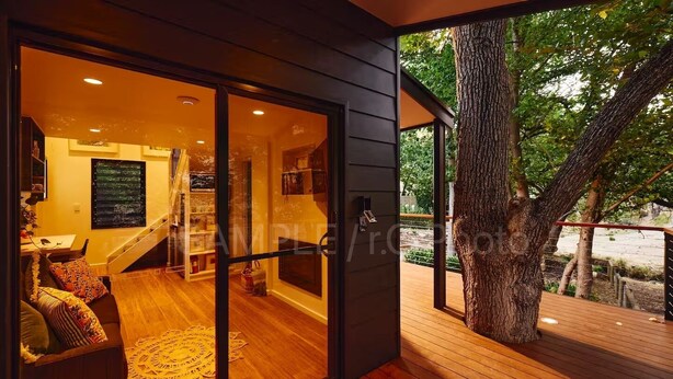 Ein modernes Interieur mit Holzboden, einer Treppe und einer Glastür, die nach draußen führt.