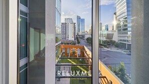 A view from a balcony with a cityscape, including modern buildings and a clear sky.