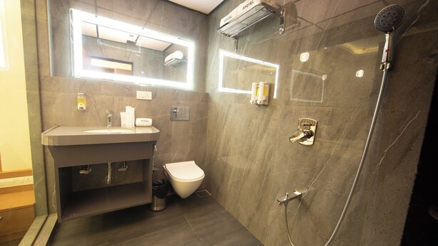 A modern bathroom with a sink, toilet, and shower. - Hotel Afotel Mumbai-Near International Airport (Mumbai)
