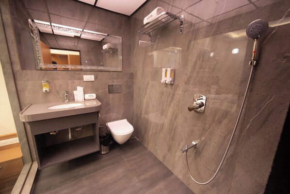 Un baño moderno con lavamanos, inodoro y ducha.