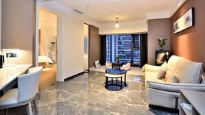 A modern hotel room with a marble floor, a sofa, a dining table with chairs, and a TV. - kunningyuehaojiudian (Kunming)