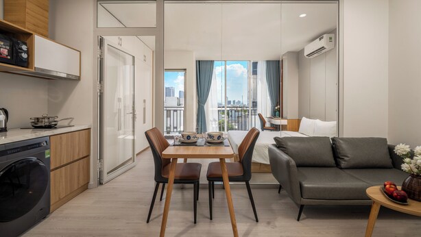 A modern apartment with a dining area, sofa, and kitchen. - TCM Hotel & Apartment (Da Nang)