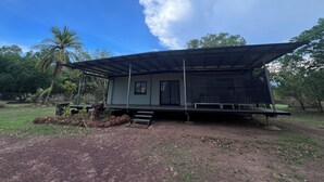 Ein Bungalow mit einer Metallbedachung und einer überdachten Veranda.