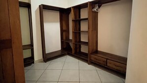 A room with a tiled floor, wooden shelving units, and a ceiling light. - Perfect 3-bedroom apartment with AC in superb Mtwapa location (Mtwapa)