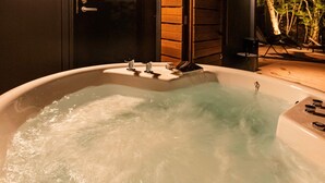 Un jacuzzi con un muelle de madera y una puerta a una habitación.
