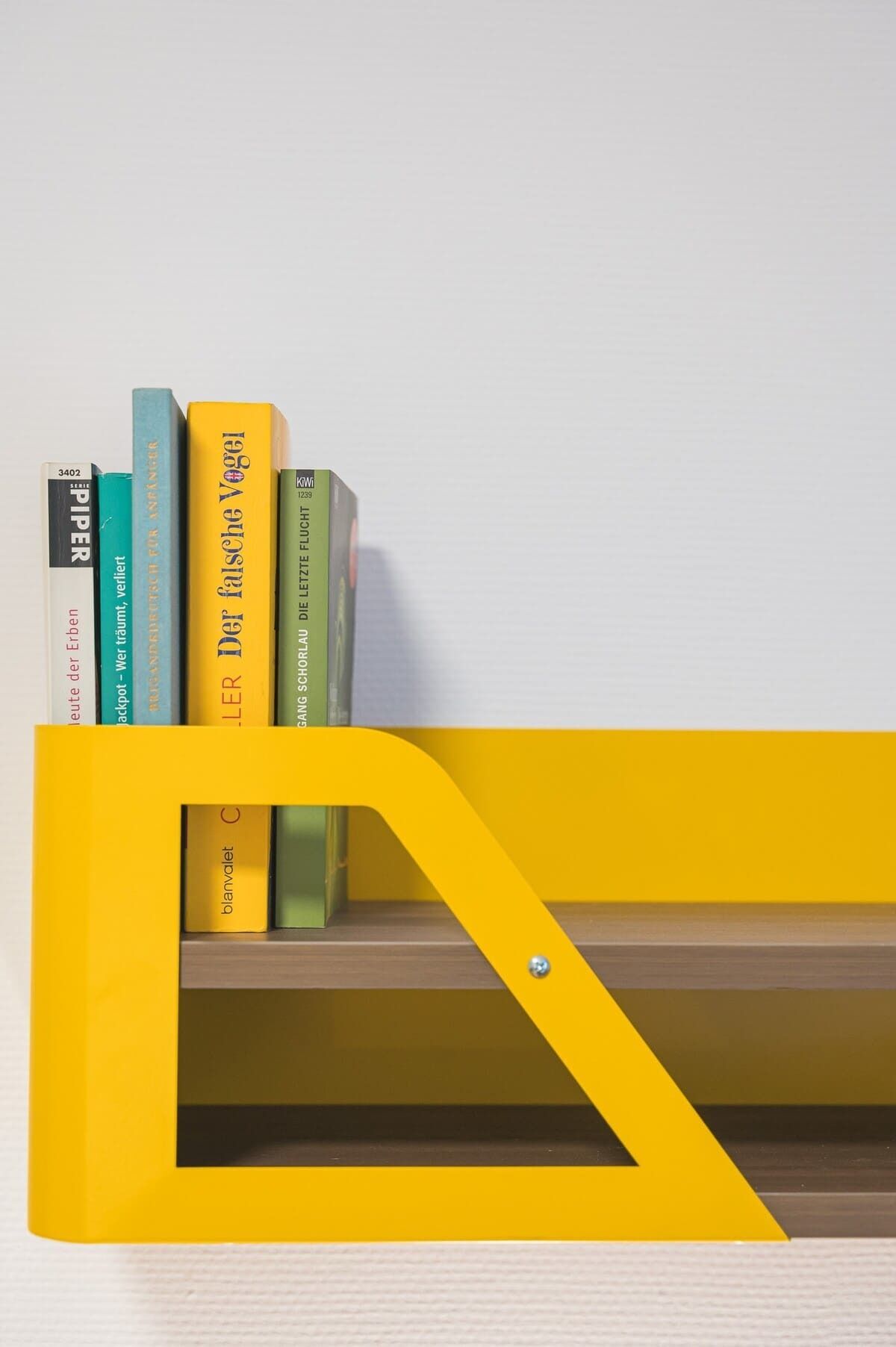 Ein Bücherregal mit Büchern und einem gelben Metallrahmen.