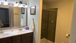 A bathroom with a double sink, a large mirror, and a glass shower enclosure. - 3-bedroom house on Eufaula Lake in delightful Porum (Porum)