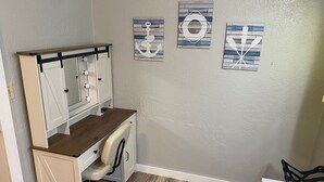 A compact office space with a desk, chair, and a vanity with mirrors. There are three wall-mounted artworks depicting nautical themes. - 3-bedroom house on Eufaula Lake in delightful Porum (Porum)