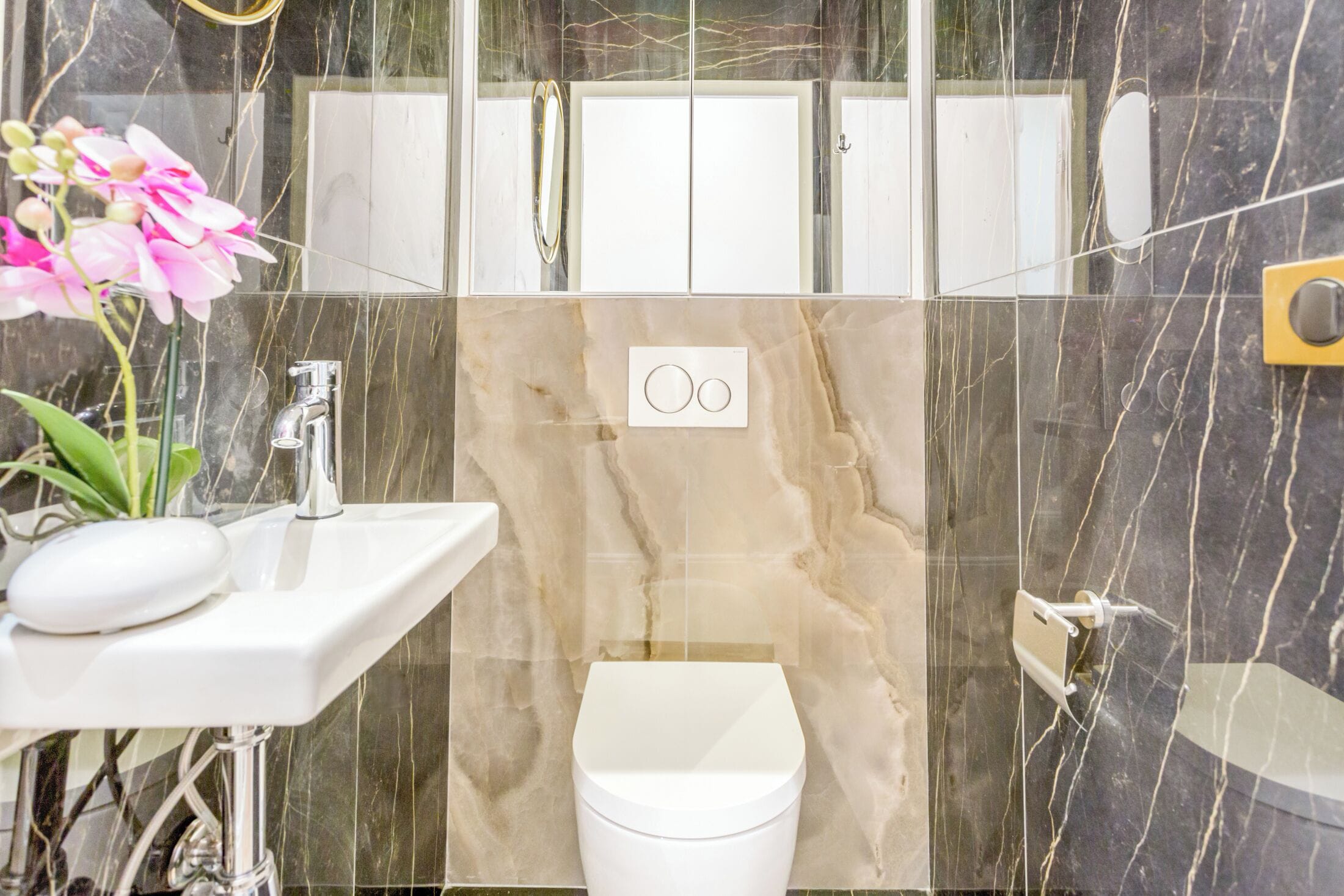 A bathroom with a white sink, a toilet, and a mirror.