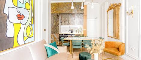 Een moderne woonkamer met een bank, salontafel, en een eethoek met stoelen en een tafel.