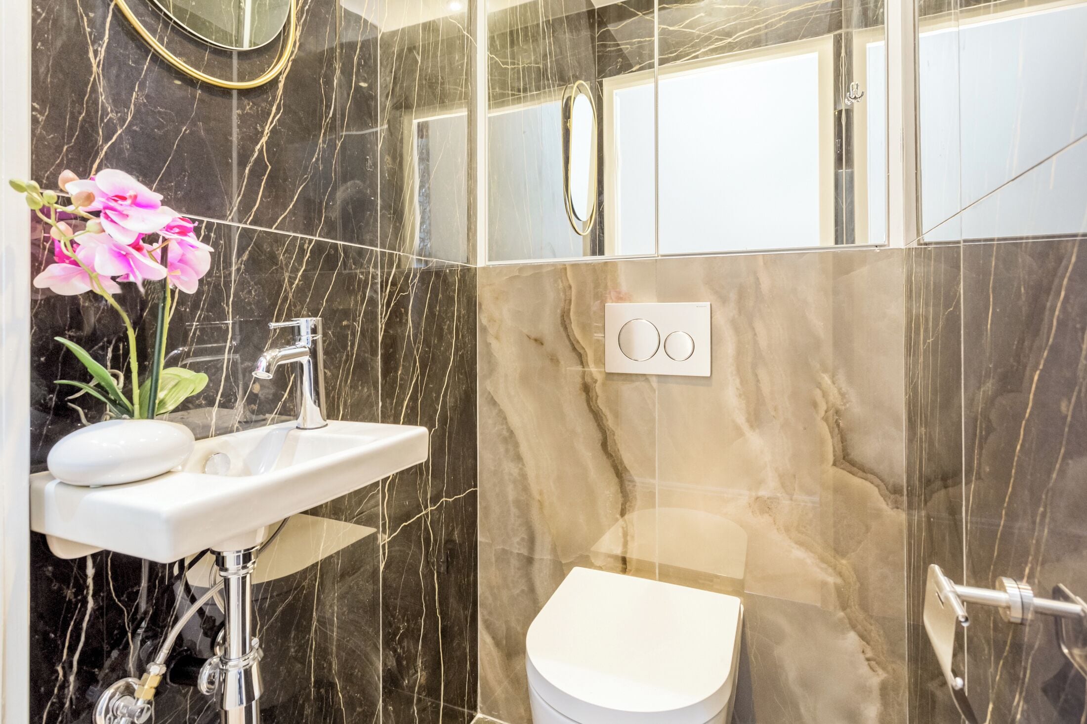 Un bagno moderno con un lavandino bianco, un water e uno specchio.