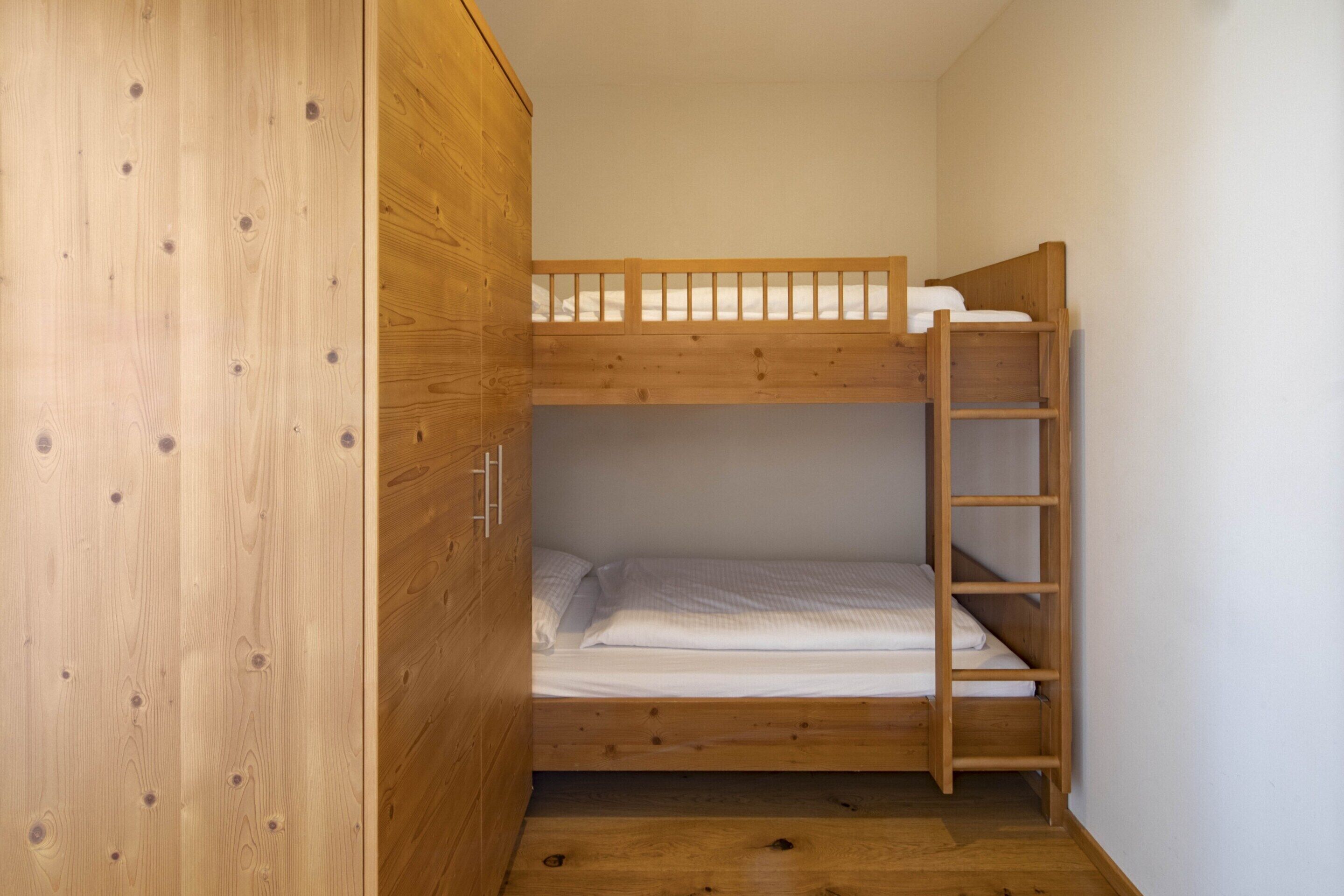 A bunk bed room with wooden walls and a ladder.