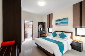 Habitación de hotel moderna con una cama grande, un escritorio, una silla, una mesita de noche y una ventana con vistas a la playa.