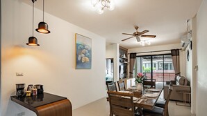 A modern kitchen with a dining area, a ceiling fan, and a large window.