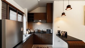 A compact kitchen with a refrigerator, stove, oven, and various appliances.