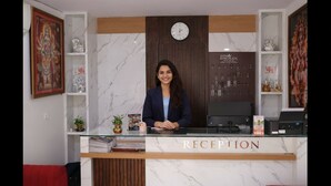 Una reception con una scrivania, un orologio e mensole con oggetti decorativi.