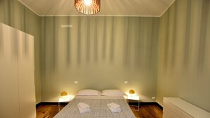 Ein Schlafzimmer mit einem Bett, zwei Nachttischen und einer Hängelampe.