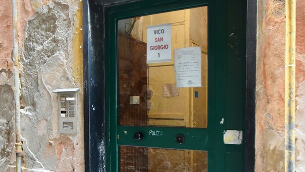 Eine grüne Tür mit einem Schild, auf dem "VICO SAN GIORGIO 1" steht.