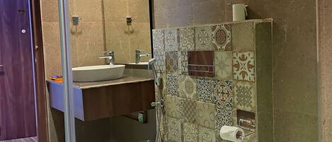 A bathroom with a toilet, sink, and shower.