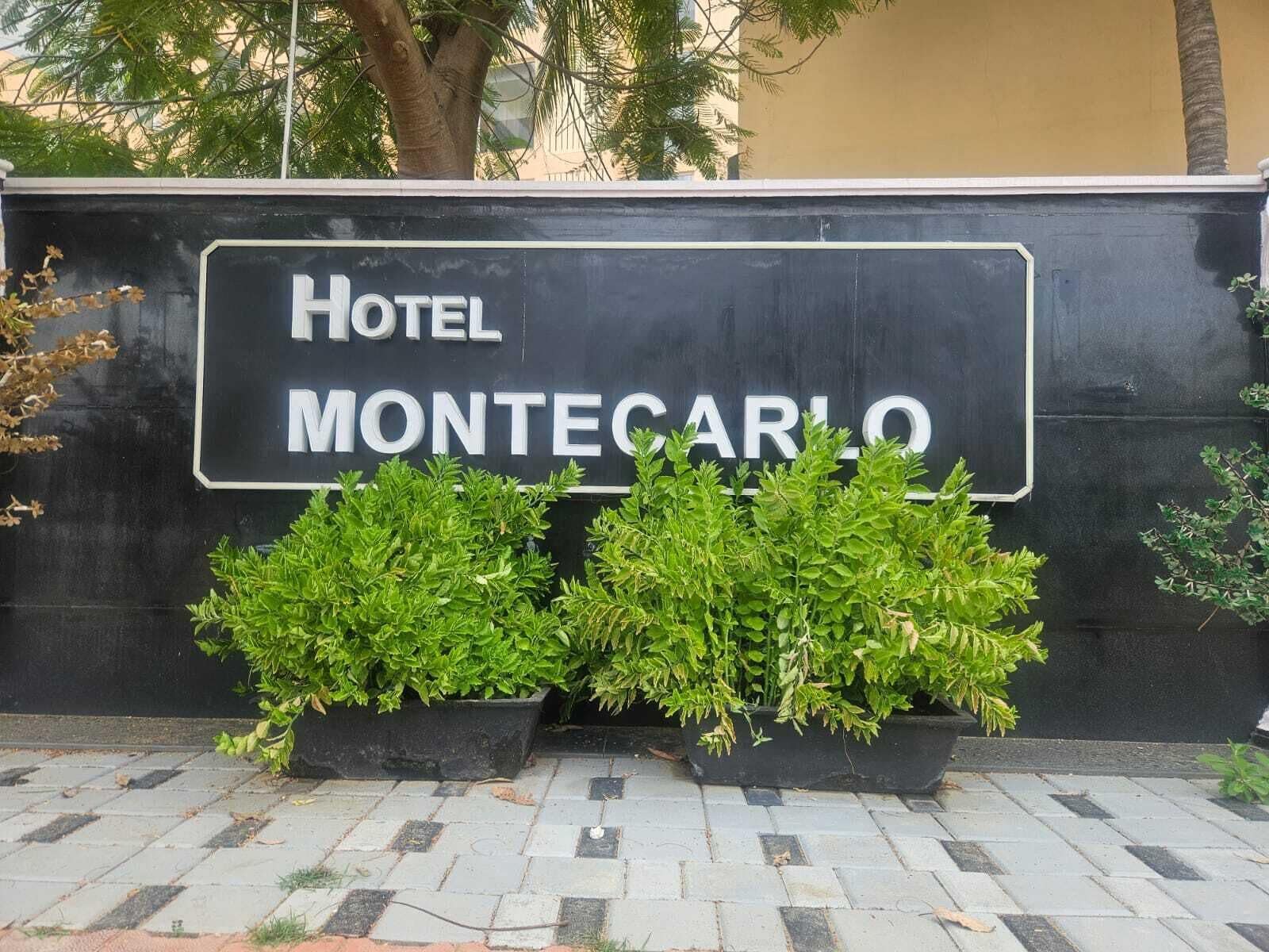 A sign for Hotel Montecarlo with a black background and white lettering.