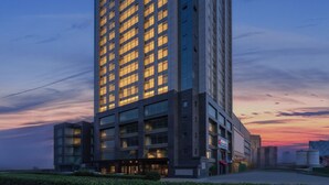 A high-rise hotel with multiple floors, large windows, and a well-lit entrance. - Beijing Chengying Hotel - Sanlitun Taikoo Li (Beijing)