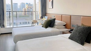 A hotel room with two beds, a desk, a chair, and a large window offering a city view. - Beijing Chengying Hotel - Sanlitun Taikoo Li (Beijing)