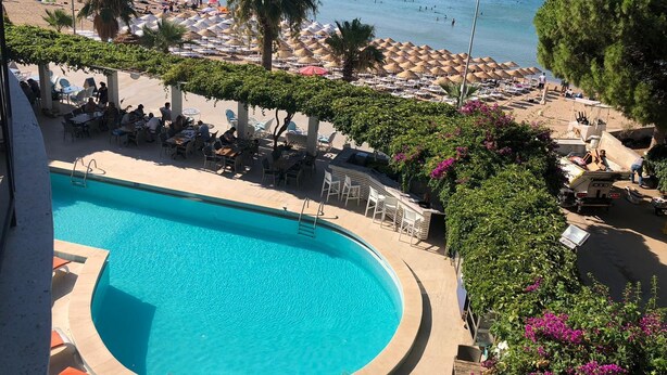 Zona de piscina con vista a la playa y al mar.