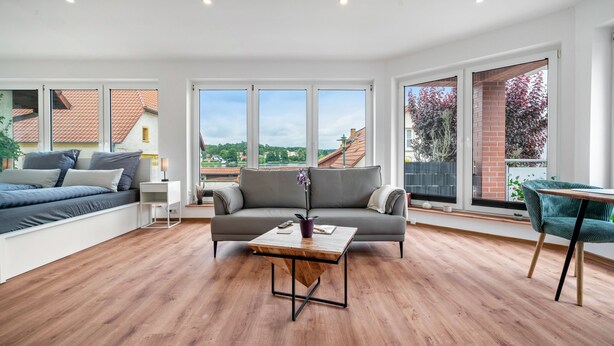 Un salón moderno con sofá, mesa de centro y vistas al exterior.