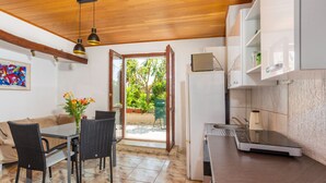 A compact kitchen with a dining area, a refrigerator, and a view of the outdoors.