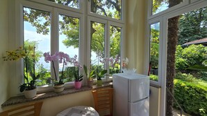 A conservatory with large windows, a refrigerator, and potted plants. - Apartman Villa Adelle - Lovran by Villas Guide (Lovran)