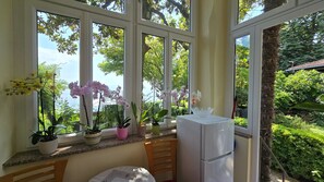 A conservatory with large windows, a refrigerator, and potted plants. - Apartman Villa Adelle - Lovran by Villas Guide (Lovran)