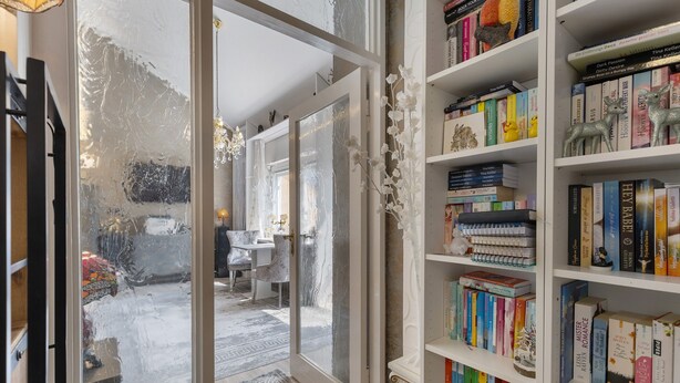 A room with a bookshelf, a door leading to another room, and a patterned rug. - Quiet Berlin-Steglitz Apartment with Shared Garden, Balcony & Wi-Fi (Berlin)