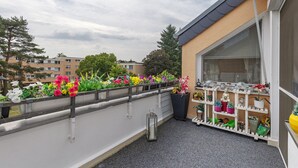 A balcony with a railing, potted plants, and a lantern. - Quiet Berlin-Steglitz Apartment with Shared Garden, Balcony & Wi-Fi (Berlin)