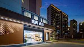 A hotel with a modern facade, large windows, and a visible interior with a seating area. - Chengdu Ximao Hotel (Chengdu)