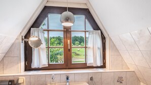 A bathroom with a skylight, a mirror, a sink, and a window with curtains. - Holiday Home 'Im Grünen' in the Leonorenwald, Near the Baltic Sea (Borkenhagen / Kalkhorst)